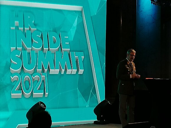 Mann hält Rede am HR Inside Summit 2021.