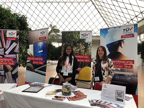 Zwei lächelnde Damen am TÜV AUSTRIA Akademie Stand.