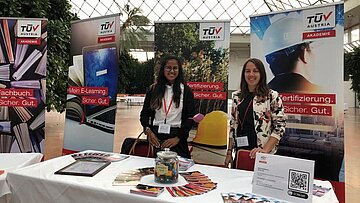 Lächelnde Dame am TÜV AUSTRIA Akademie Stand.