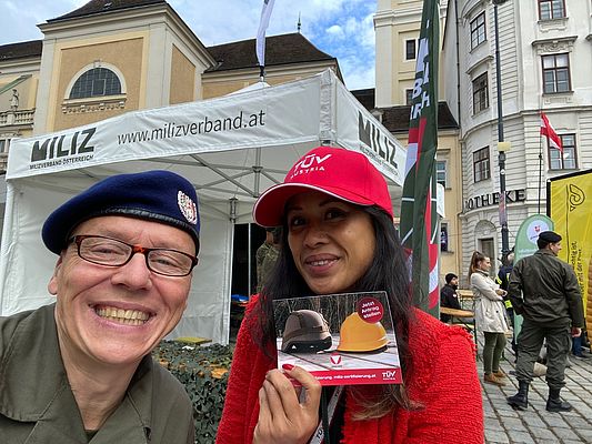 Uniformierter Herr und Dame mit TÜV AUSTRIA Kappe.