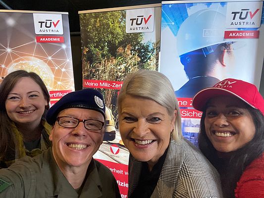Selfie: Drei Damen und ein Herr vor TÜV AUSTRIA Akademie Rollups.